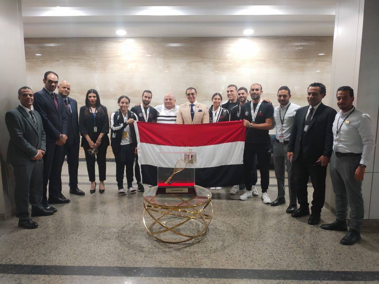 صورة استقبال رسمي لبعثة منتخب الاسكواش في مطار القاهرة بعد الفوز بكأس العالم 